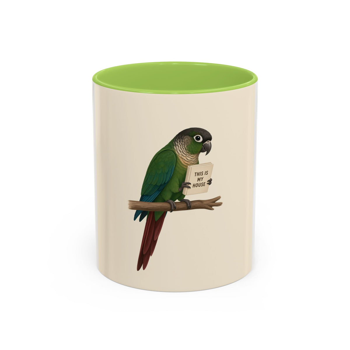 A ceramic mug with a white and cream-colored exterior and a green interior, featuring a printed illustration of a green parrot perched on a branch holding a sign that reads 'THIS IS MY HOUSE'.