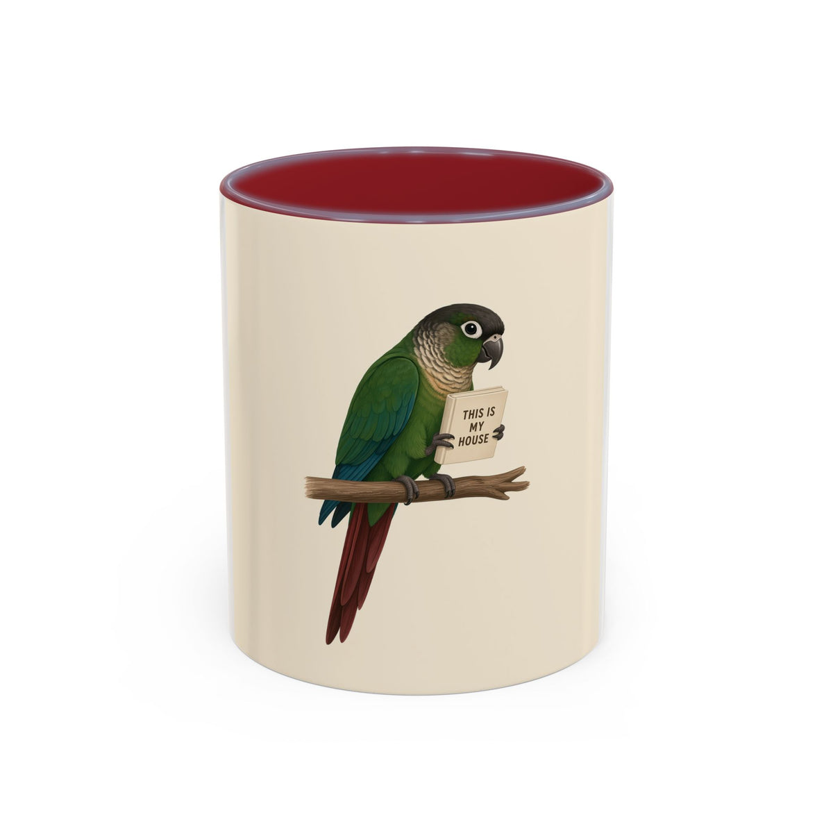 A ceramic mug with a white and cream-colored exterior and a black interior, featuring a printed illustration of a green parrot perched on a branch holding a sign that reads 'THIS IS MY HOUSE'.